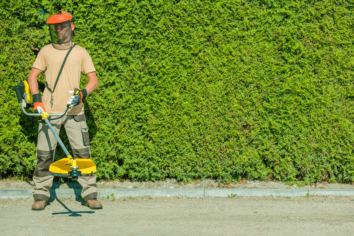 Gas String Trimmers Work. Caucasian Garden Worker with Power Tool.